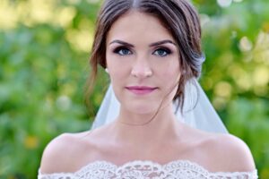 Beauty bride in bridal gown with lace veil in the nature