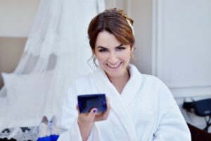 Beauty bride in dressing gown with bridal makeup indoors